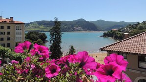 A coastal view with a beach, mountains, and buildings. - Apartamentos Mundaka (Mundaka)