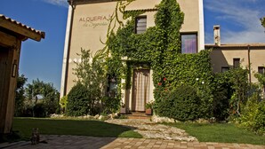 Un edificio con un cartel que dice "ALQUERIA de Egouia" y un camino de piedra que lleva a la entrada.