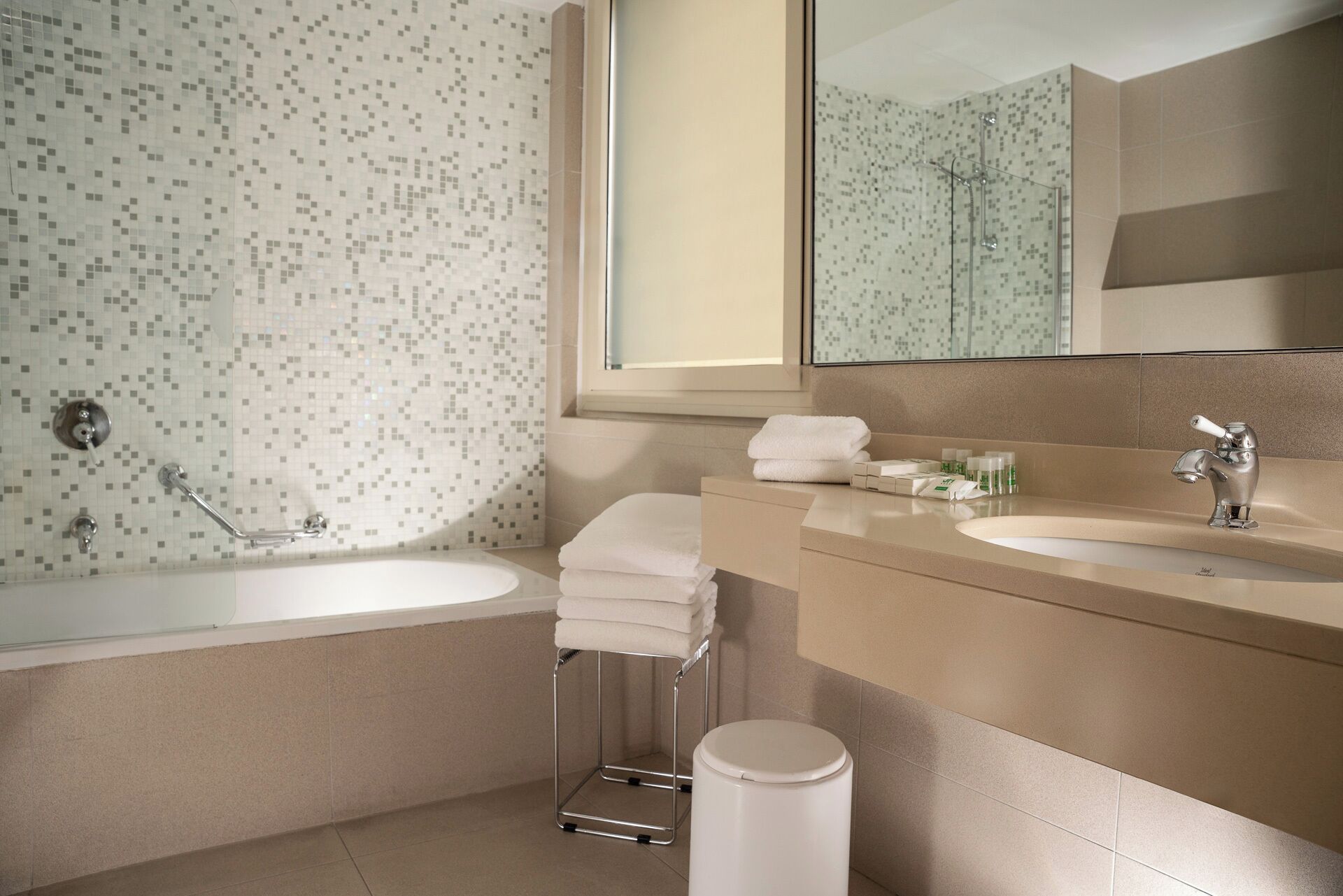 A modern bathroom with a large bathtub, a separate shower area, and a vanity with a sink and mirror.
