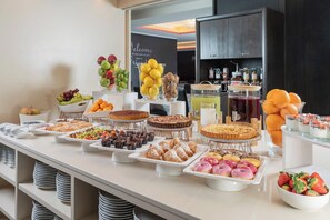 A buffet with various desserts and fruits.