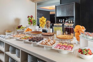 A buffet with various desserts and fruits.