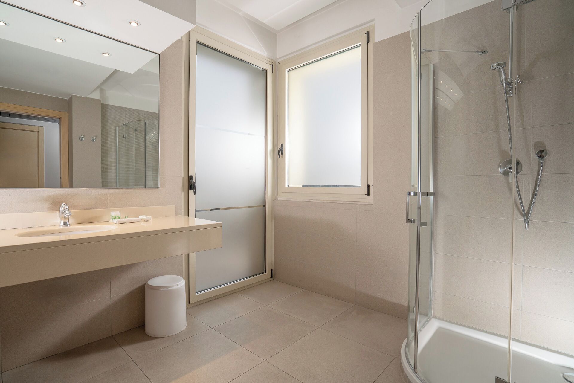 Une salle de bain moderne avec une douche à parois de verre, un meuble-lavabo avec un miroir et des toilettes.