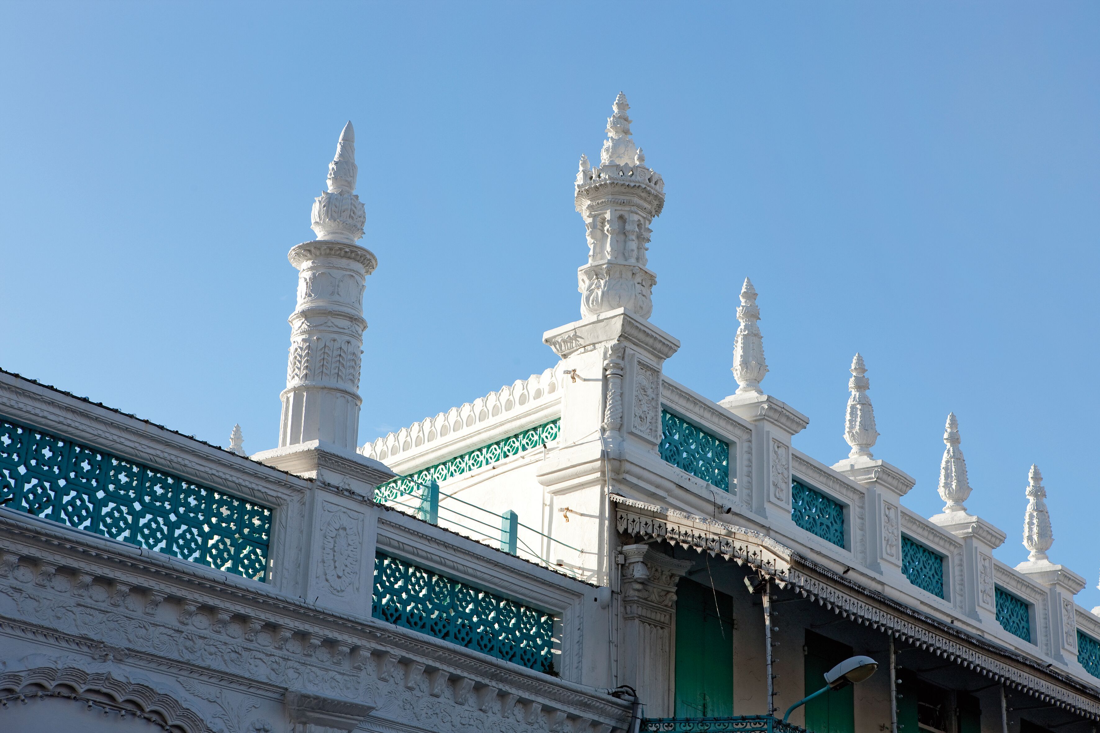 A white building with ornate architectural details, including multiple spires and decorative elements.