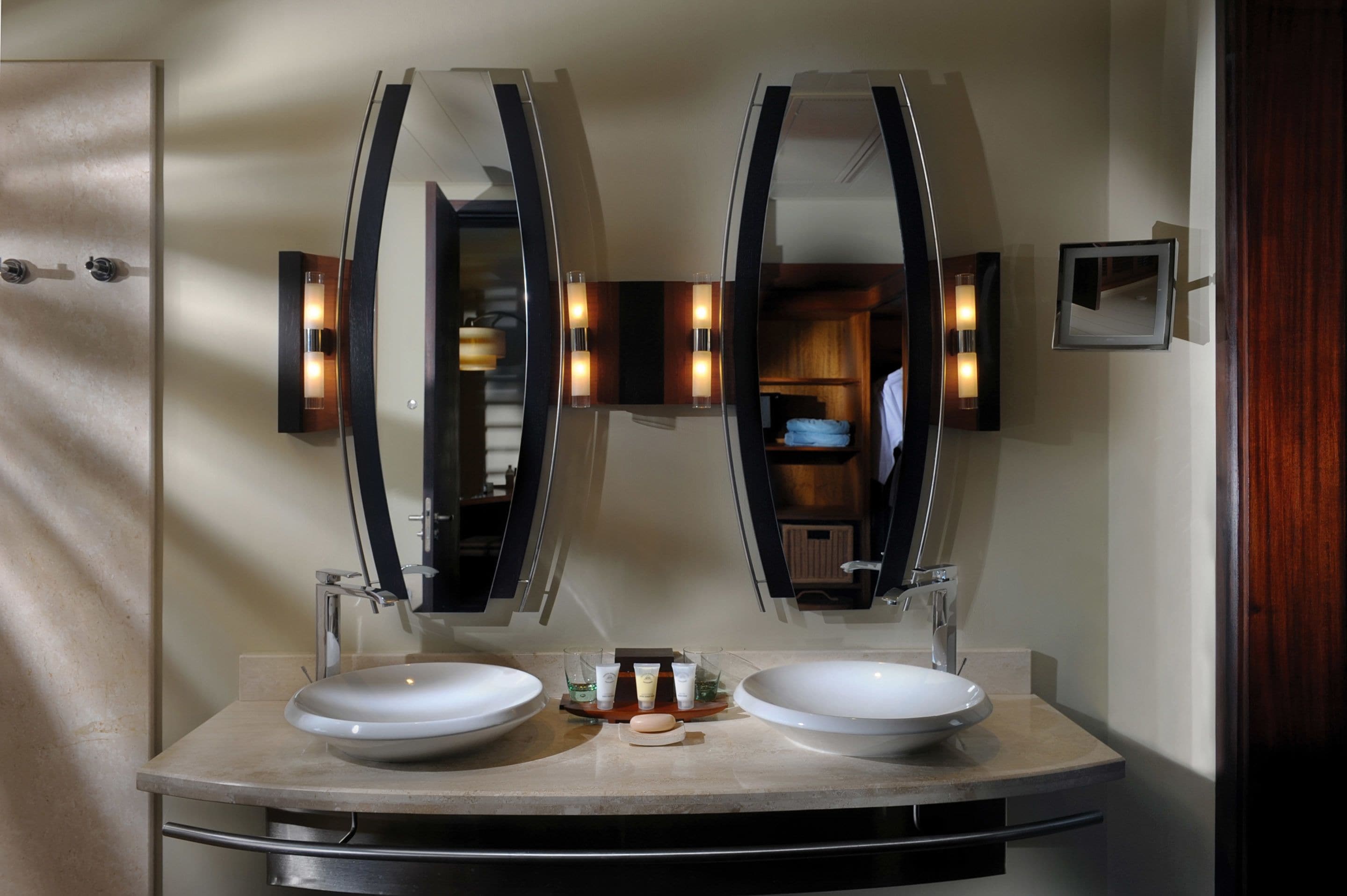 A bathroom with two sinks, a mirror, and a towel rack.