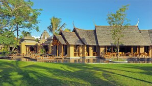A traditional building with a central courtyard, wooden structures, and a reflective water feature. - Trou aux Biches Beachcomber Golf Resort & Spa (Trou aux Biches)