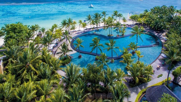 An aerial view of a resort with a central swimming pool surrounded by palm trees and a beach. - Trou aux Biches Beachcomber Golf Resort & Spa (Trou aux Biches)