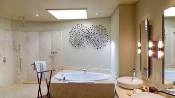 Une salle de bain moderne avec une baignoire sur pieds, deux vasques et un grand miroir fixé au mur.