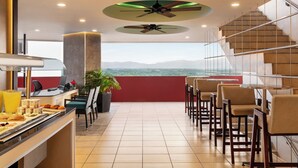 Ein Restaurant mit Terrasse, Essbereich und einer Treppe.