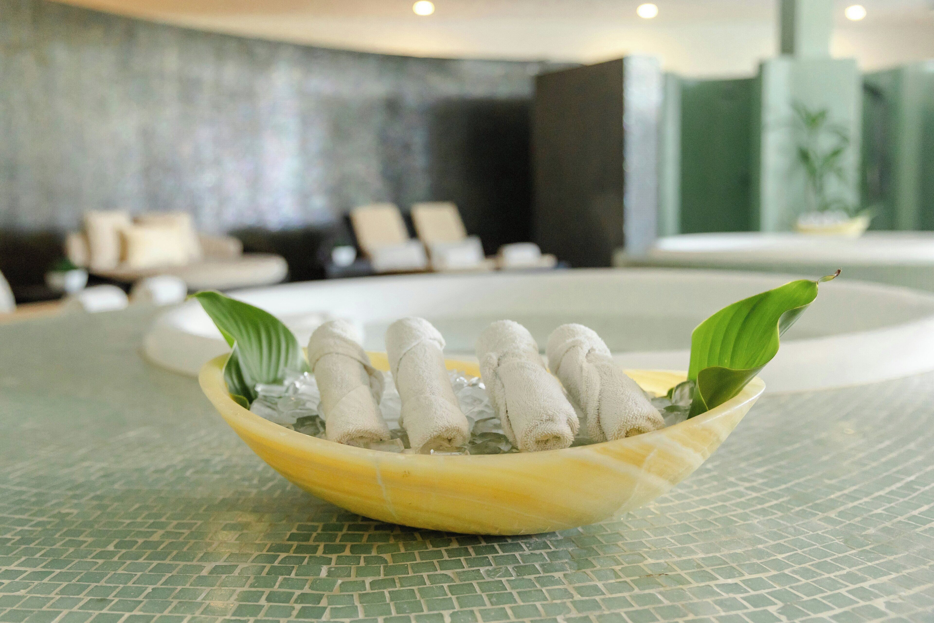 A bowl of towels on a tiled surface.