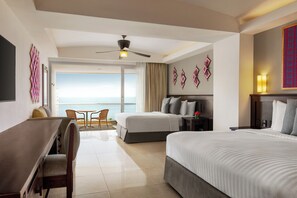 A hotel room with a large bed, a desk, and a chair. There is a balcony with a view of the ocean. - Fiesta Americana Riviera Nayarit Resort All Inclusive & Spa (Nuevo Nayarit)