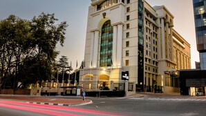 A hotel with a prominent arched entrance and a sign reading "Southern Sun." - Southern Sun Sandton (Sandton)