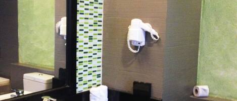 Une salle de bain avec un lavabo blanc, un porte-serviettes, un miroir et des toilettes.