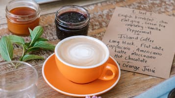 A table with a coffee cup, sliced fruits, and a menu.