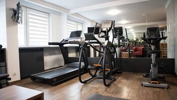 A home gym with a treadmill, elliptical, and various exercise equipment.