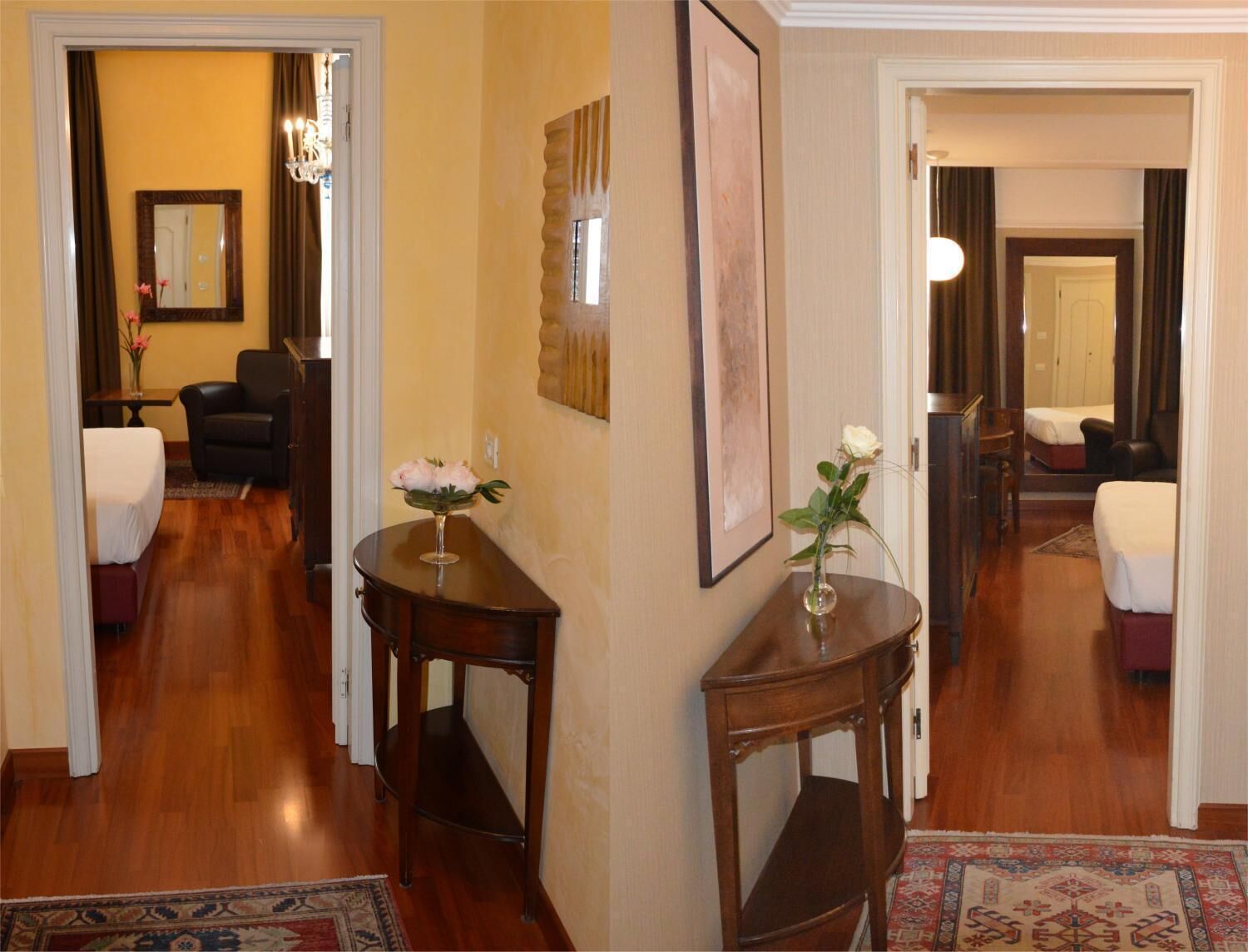 A hotel lobby with wooden flooring, a reception desk, a seating area with a chair, and a bed in the background.