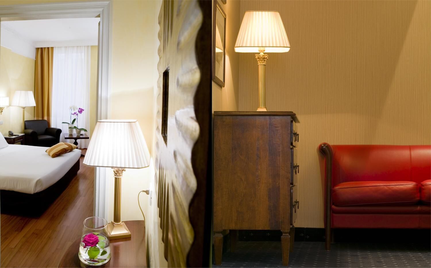 Ein Hotelzimmer mit Bett, Nachttisch mit Lampe, einer Vase mit einer Blume, einem roten Ledersofa und einem Holzkasten.