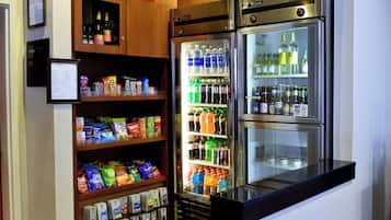 A vending machine with snacks and drinks, a refrigerator with beverages, and a small display case with bottled water.
