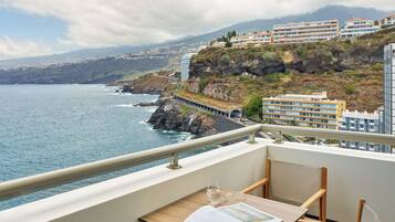 Un balcon avec une table, une paire de lunettes et un magazine ouvert.