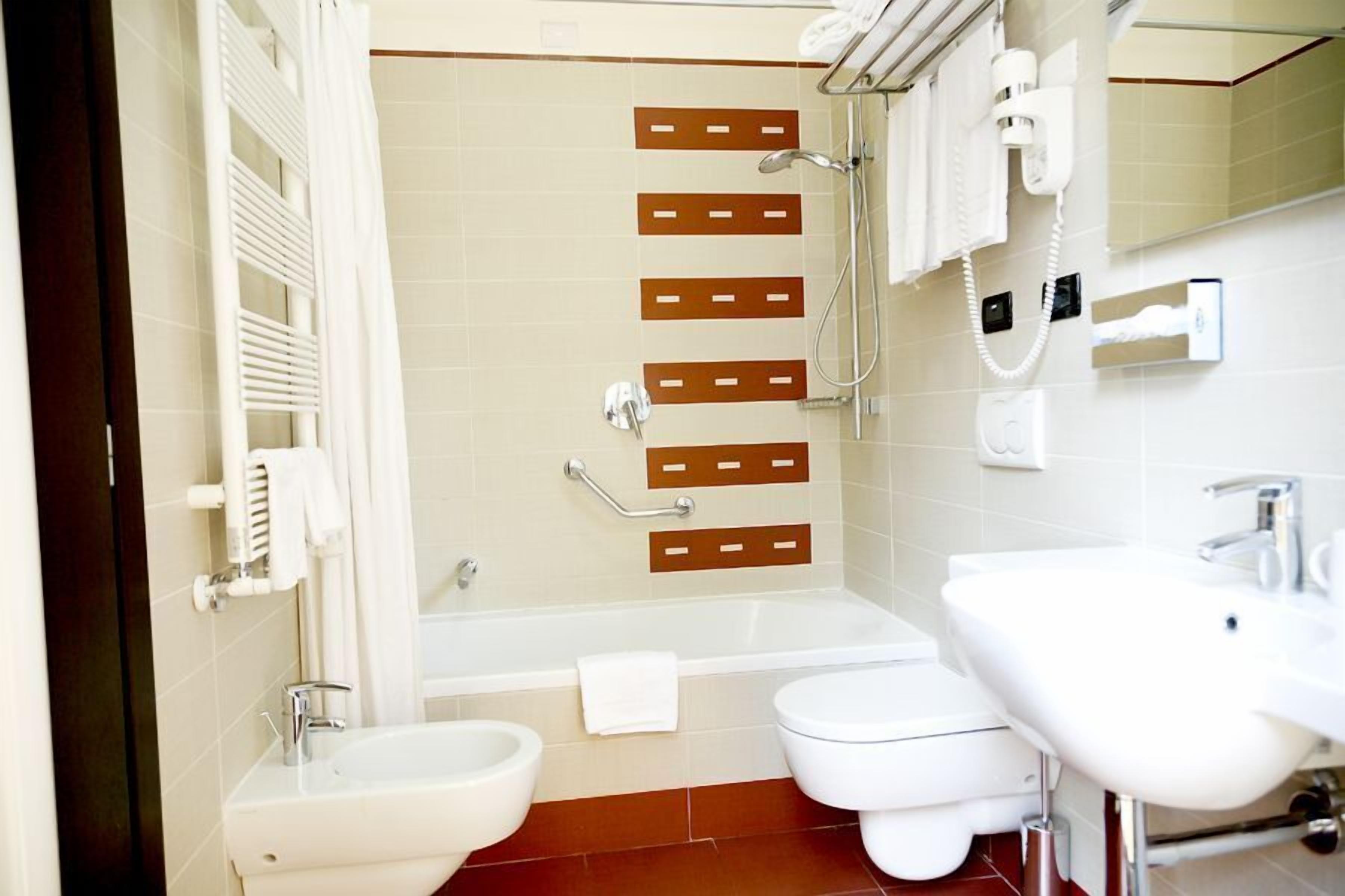 A bathroom with a bathtub, two sinks, a toilet, and a shower.