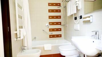 A bathroom with a bathtub, two sinks, a toilet, and a shower.