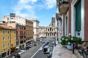 A street view with a prominent building with a dome and clock tower in the background. - Merulana Inn Guest House (Rome)