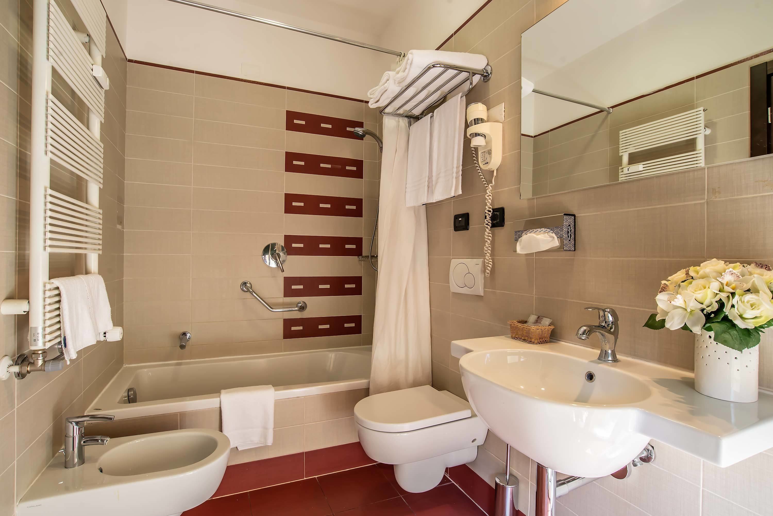 A modern bathroom with a bathtub, toilet, and sink.