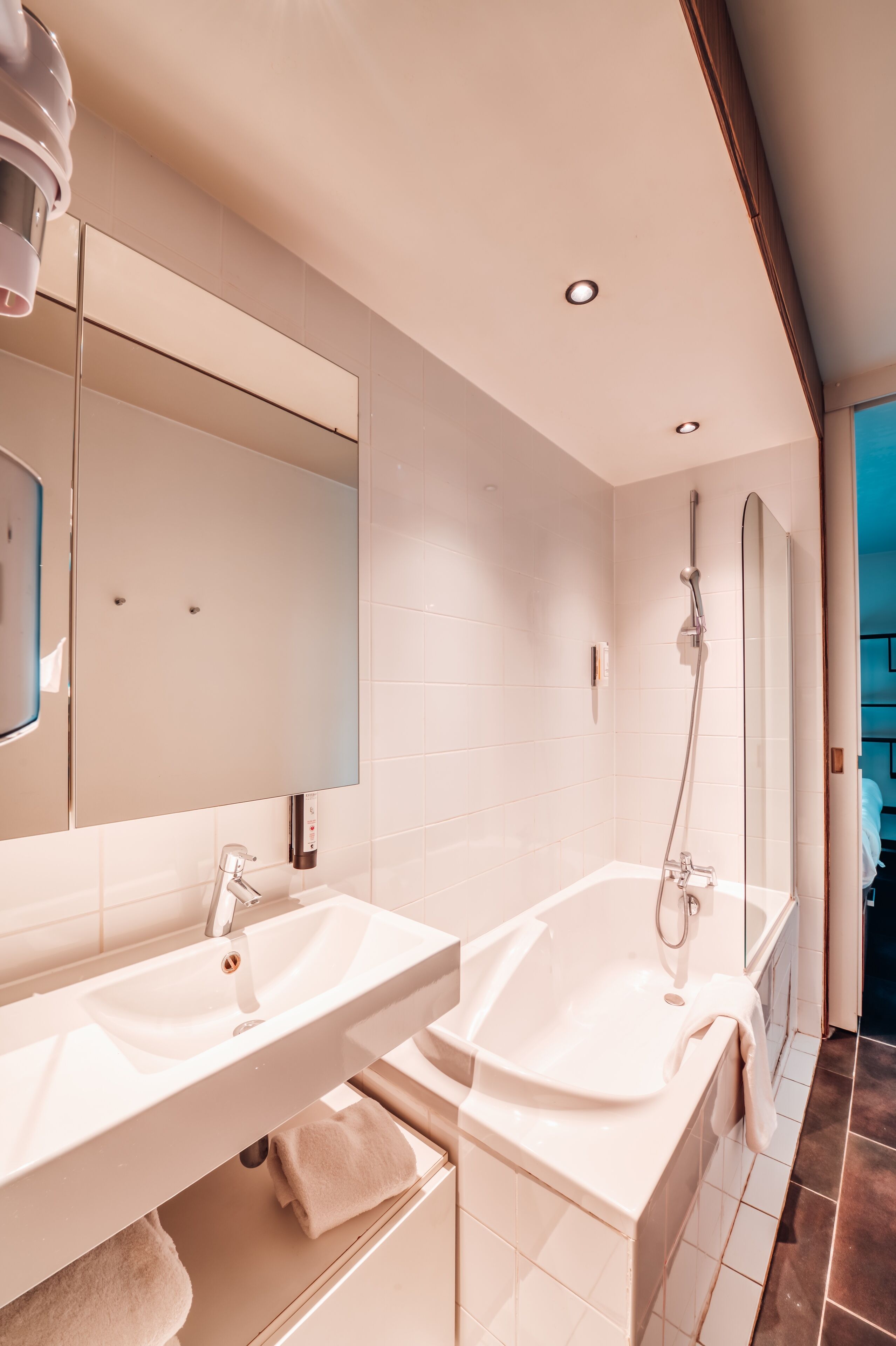 Un baño moderno con dos lavamanos, un espejo grande y una ducha a pie.