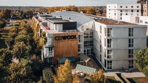 Un bâtiment moderne, facilement reconnaissable à son grand panneau « COWOL », doté de plusieurs étages, de grandes fenêtres et d’un toit équipé de panneaux solaires.