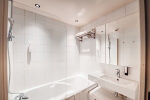 Un baño moderno con bañera, ducha y lavamanos.