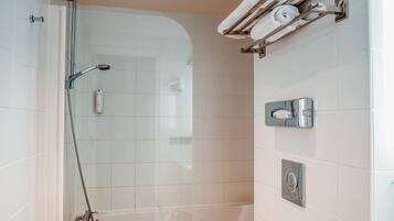 A modern bathroom with a glass-enclosed shower, a white toilet, and a towel rack with towels.