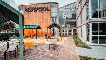 Um edifício moderno com uma placa que diz "COWOOL COSY LIVING & COSY WORKING".
