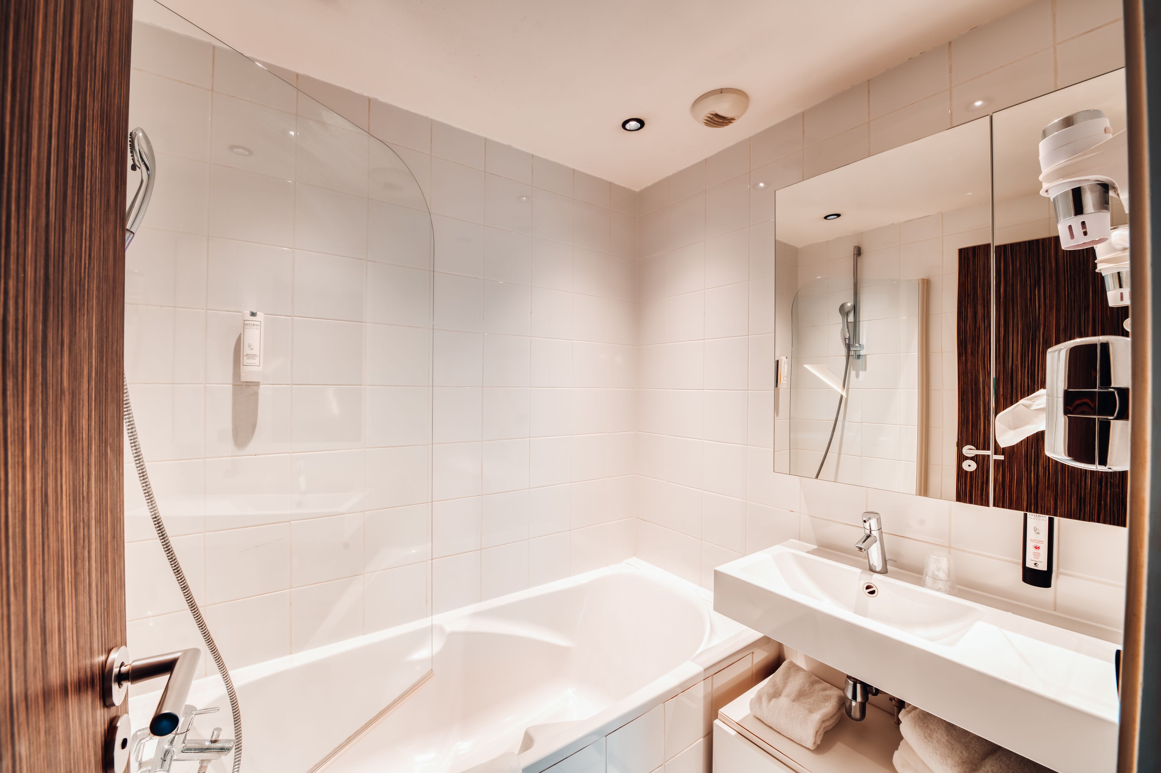 A modern bathroom with a bathtub, a sink, and a shower.