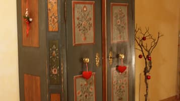Un meuble en bois foncé orné de motifs floraux et rehaussé d’accents rouges, placé contre un mur jaune.