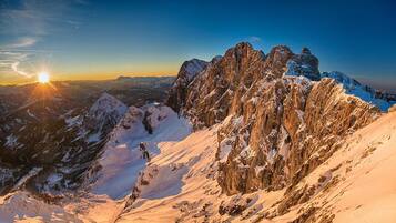 Paisaje montañoso con picos nevados y cielo despejado.