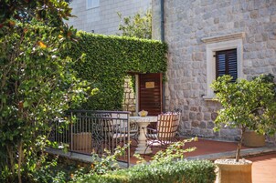 An outdoor patio with a stone wall, a wooden door, and a metal fence.