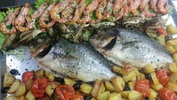 A seafood platter with grilled shrimp, fish, and roasted vegetables.