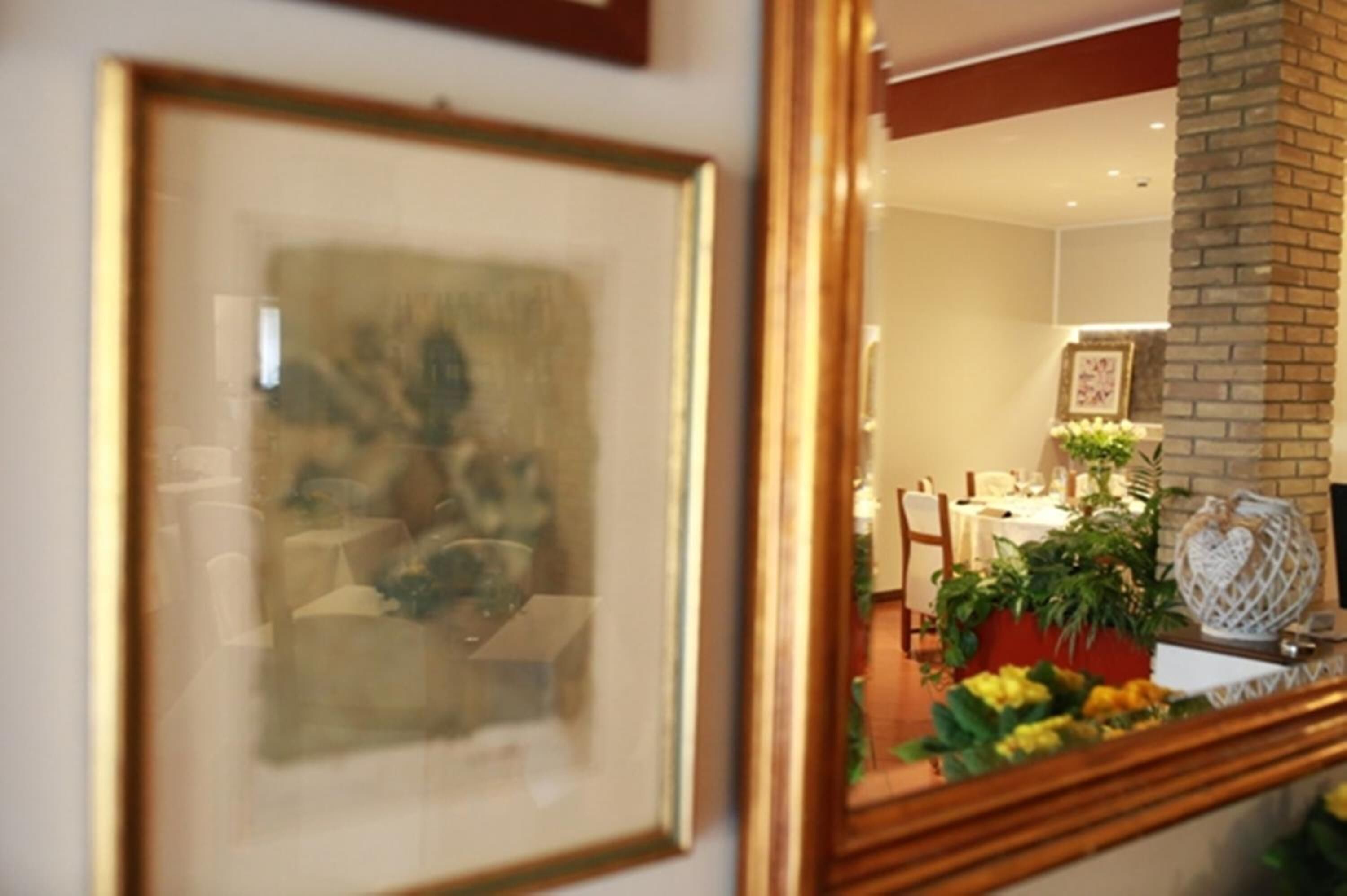 Une œuvre d’art encadrée accrochée au mur, une cheminée en briques et un coin repas avec une table mise pour deux personnes.