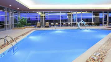 Una piscina techada, sillones reclinables de piscina