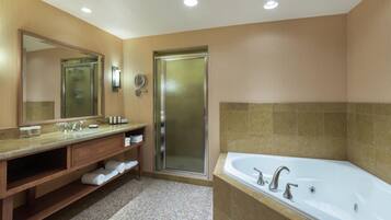 A modern bathroom with a vanity, a large mirror, a shower enclosure, and a bathtub.