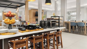 A modern kitchen with a central island, bar stools, and a variety of appliances including a coffee maker and a toaster.