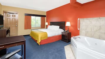 Une chambre d’hôtel comprenant un lit, un bureau, une télévision, une salle de bain avec baignoire et une fenêtre avec des rideaux.