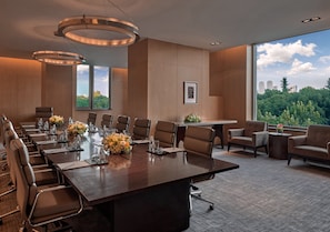 A conference room with a long table, chairs, and a view of the cityscape through large windows. - Marco Polo Wuhan (Wuhan)