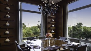A dining area with a table set for six, large windows, and a chandelier. - Marco Polo Wuhan (Wuhan)