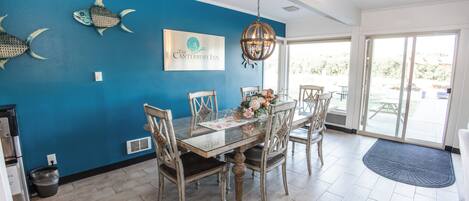 A dining area with a blue wall, a chandelier, and a sign for The Canterbury Inn.