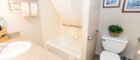 A bathroom with a sink, bathtub, toilet, and towel rack.