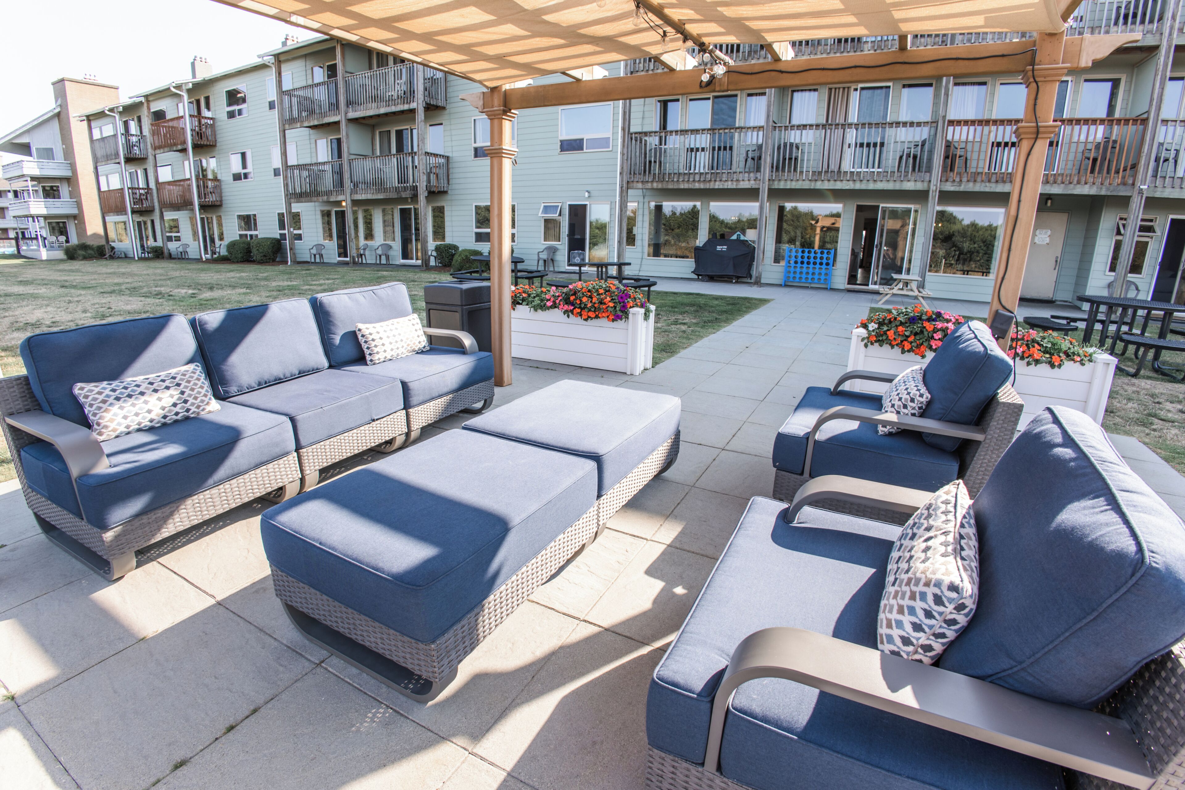 Une terrasse extérieure aménagée avec des meubles en osier et des jardinières.