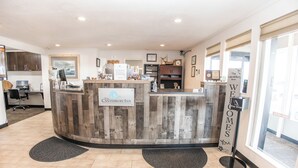 A reception desk with a wooden design, a sign reading 'The Canterbury Inn,' and a 'Welcome You' sign.