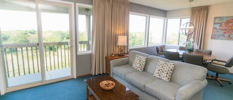 A spacious living room with a sofa, coffee table, and dining area.