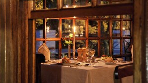 A table set for dinner with candles, a vase with a flower, and dishes. - Coach House Hotel & Spa (Tzaneen)