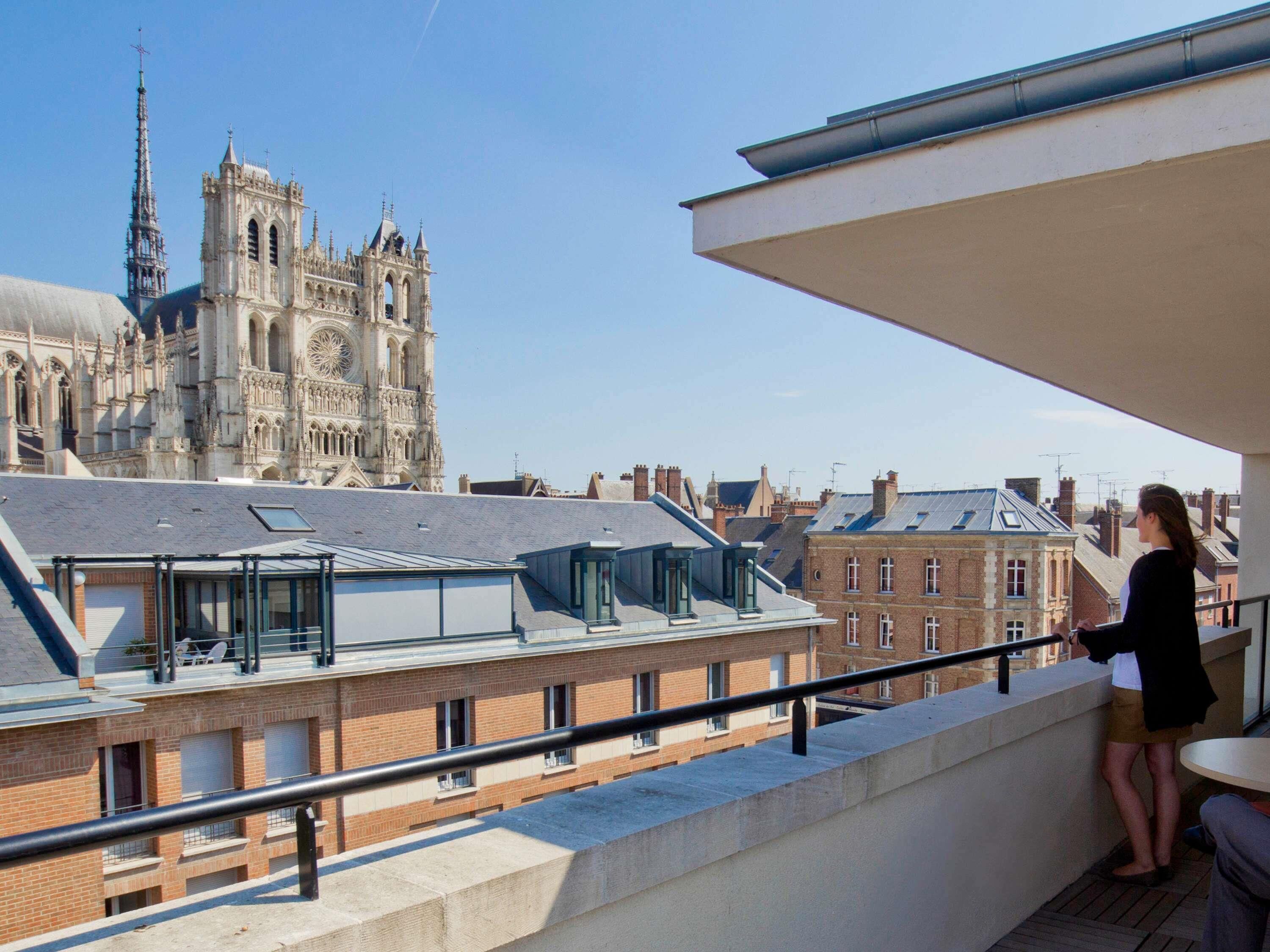 A balcony with a view of a historic cathedral and surrounding buildings.